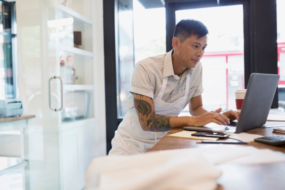 Bakery business owner working at laptop