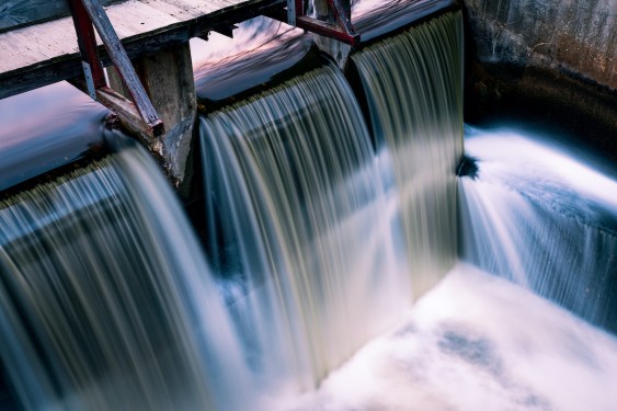 Long exposure spillway shines water and light. Copy space.