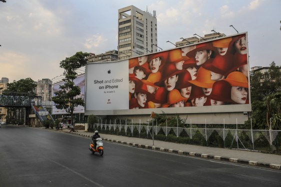 Scooter rider driving past billboard