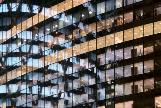 Reflection of Illuminated office building in glass office facade in Paris, France.