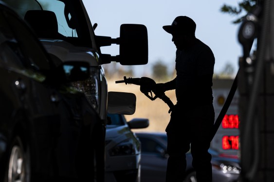 person refueling car with gas pump