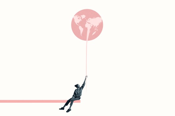 Young woman holding at large pink balloon with world map while sitting on ramp against white background