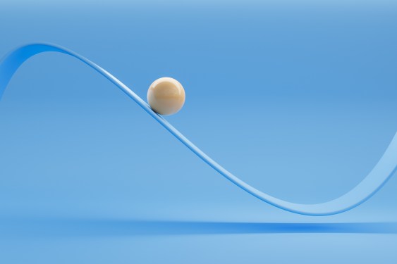 Image of a glossy white ceramic ball moving along an oscillating curve against a blue background.