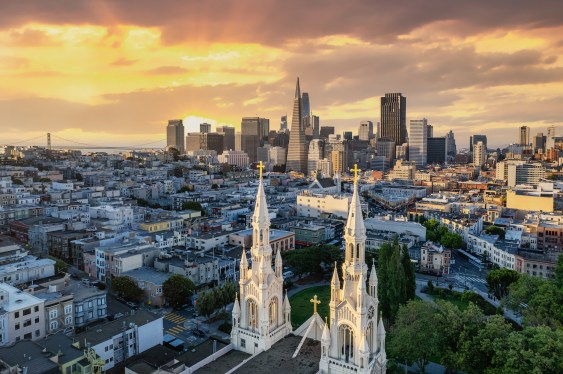 Aerial view through the church spires looking at the downtown district as the sun rises.