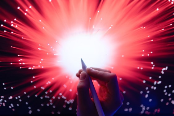 Artist with digital pencil editing digital image of light burst.