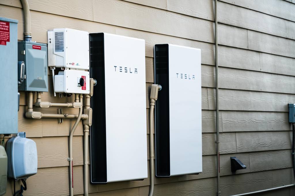 Two Tesla Powerwalls sit on the outside of a house.