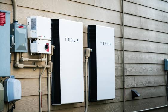 Two Tesla Powerwalls sit on the outside of a house.