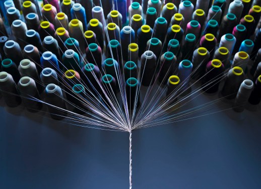 Spools of thread being twisted together.