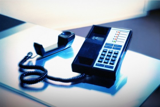 a desk phone with its receiver off the hook
