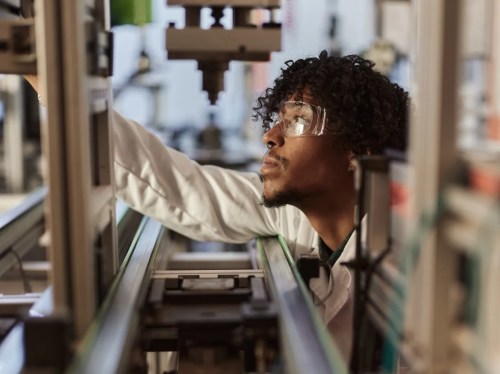 Researcher inspects equipment in a lab.
