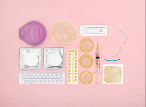 multiple contraceptives on a pink background