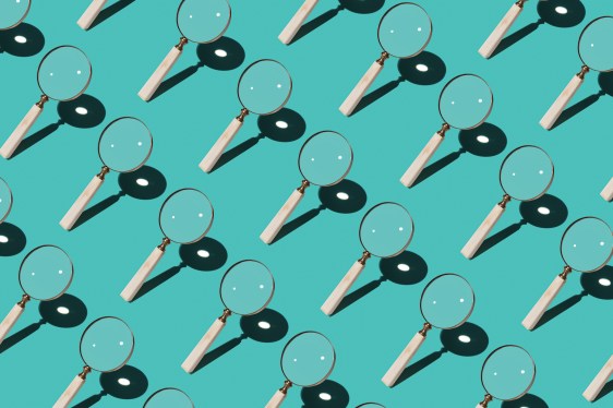 Magnifying Glass Focusing Sunlight Into a Point Repetition on Turquoise Colored Background High Angle View.