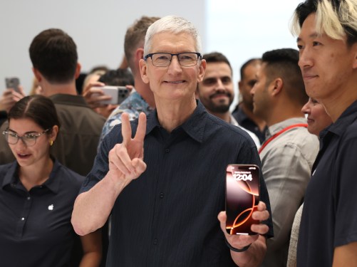 Apple CEO Tim Cook inspects the new iPhone 16 during an Apple special event at Apple headquarters.