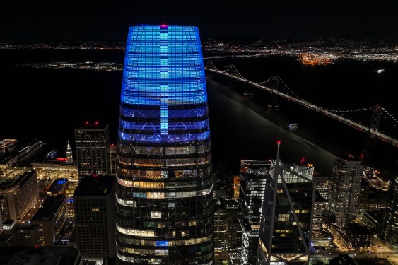 An aerial night view of Salesforce Tower and buildings in San Francisco.