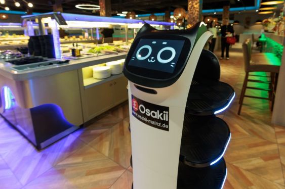 an autonomous service robot with a friendly cat face and colorful lights, is at work in the Asian restaurant