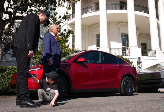 X Æ A-Xii, the son of White House Senior Advisor, Tesla and SpaceX CEO Elon Musk, plays with a toy car as Musk and U.S. President Donald Trump speak alongside a Tesla Model Y and a Cyber Truck on the South Lawn of the White House on March 11, 2025.