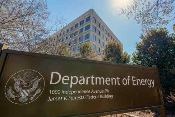 The U.S. Department of Energy building is seen behind a sign marking the location of the agency's headquarters.