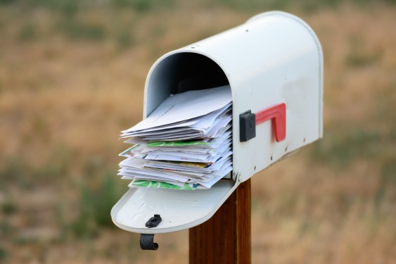 A mailbox overflows with mail.