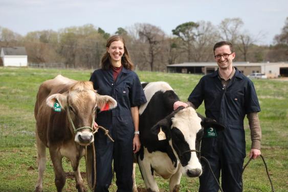 Hoofprint founders stand with two cows.