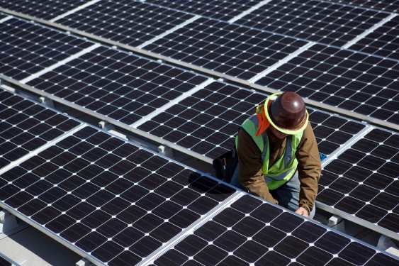 A man inspects solar panels.