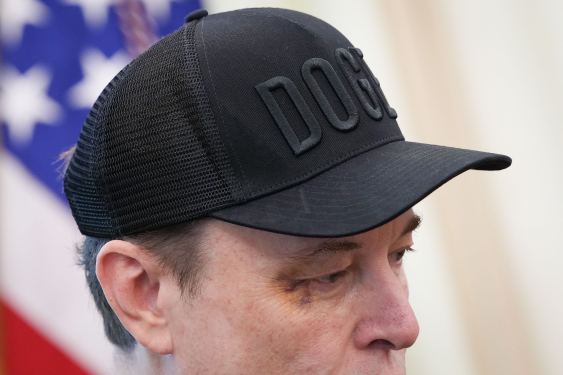 Tesla CEO Elon Musk listens as U.S. President Donald Trump speaks to reporters in the Oval Office.