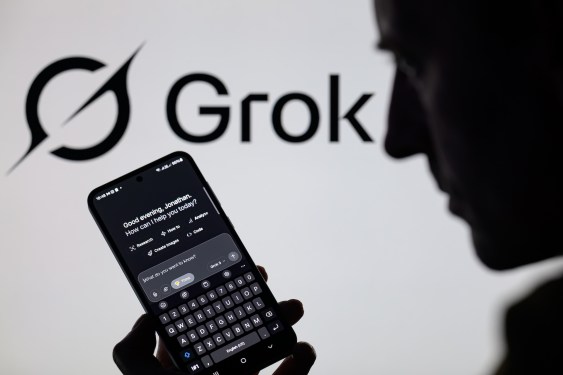 The Grok X AI app is used on a mobile phone with the Grok logo visible in the background.