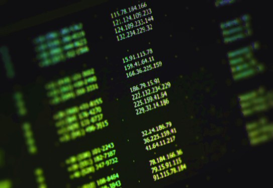 a stock photo of a list of random IP addresses in green text on a computer monitor at an angle