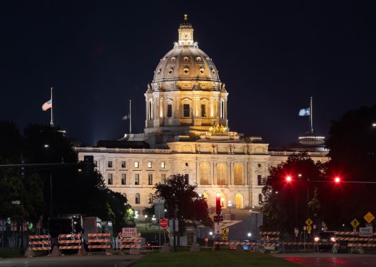 A scenic view of the majestic Minnesota State Capitol building in St. Paul, dramatically illuminated against the night sky
