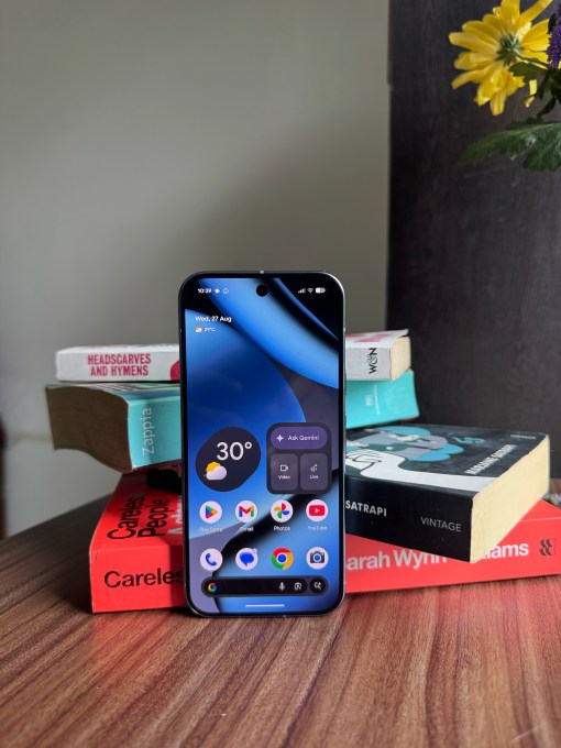 An Image of the Google Pixel 10 Pro device facing the screen with books in the background.