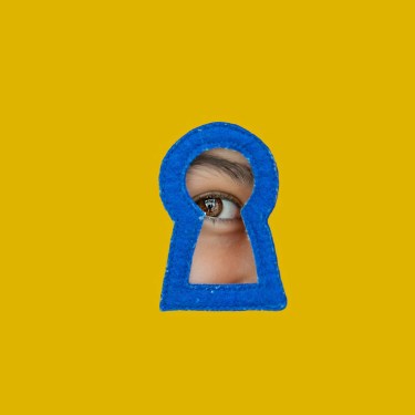 a child looking through a blue keyhole