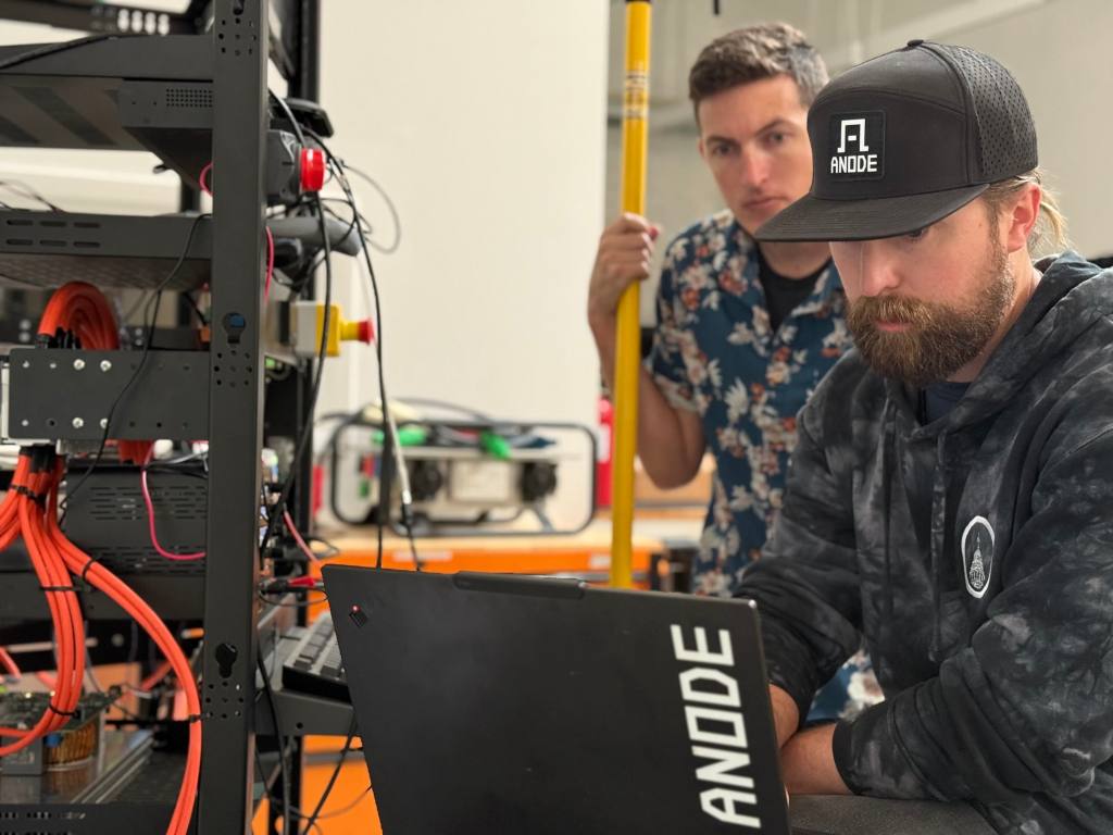 Anode engineers work on a laptop.