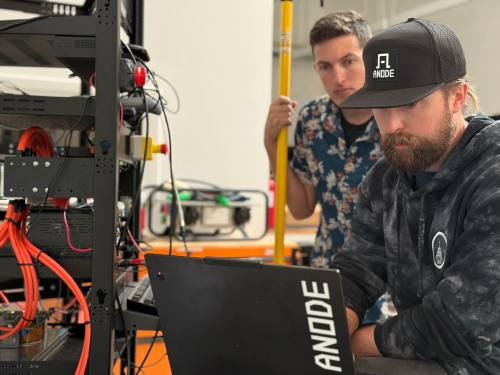 Anode engineers work on a laptop.
